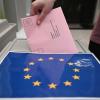 Ein Wahlbrief mit einem Stimmzettel für die Europawahl wird in einem Wahllokal für die Briefwahl in eine Wahlurne gesteckt.