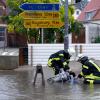 Im Dauereinsatz waren die Rettungskräfte am Wochenende - unter anderem in Dasing. Das Bild zeigt Feuerwehrleute, die auf einer überschwemmten Straße eine Pumpe aufbauen. 