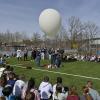 Schülerinnen und Schüler der P-Seminare Physik und Chemie lassen Sportplatz des DZG in Landsberg einen Stratosphärenballon steigen. Die halbe Schule schaut dabei zu.