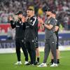 Stuttgarts Cheftrainer Sebastian Hoeneß (r) steht mit seinem Trainerteam nach dem Spiel auf dem Platz.