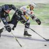 Michael Clarke von den Straubing Tigers (l) und Frederik Tiffels von den Eisbären Berlin kämpfen um den Puck.