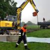 Helfer in Heißesheim bauen eine Barrikade mit Betonquadern, um sich gegen das Hochwasser zu schützen. Die Erkenntnisse aus der Lage helfen, die 