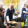 Kai Wegner (CDU, M), Regierender Bürgermeister von Berlin, serviert Essen während eines Osterbrunchs für Menschen ohne Wohnung.