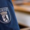 Ein Abzeichen mit dem Wort «Justiz» und dem Landeswappen von Berlin ist an der Uniform eines Justizvollzugsbeamten im Kriminalgericht Moabit angebracht.