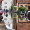 Radler fahren durch eine überflutete Straße. Im Bereich der Gemeinde Baar-Ebenhausen war ein Damm an zwei Stellen geborsten.