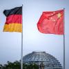 Die Flaggen von Deutschland und China wehen vor der Kuppel des Reichstagsgebäudes.