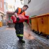 Ein Feuerwehrmann verteilt in der Altstadt von Augsburg Granulat, um Öl zu binden.