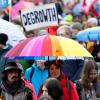 Zahlreiche Menschen nehmen auf dem Königsplatz an einer Demonstration zum Klimastreik teil und halten ein Plakat mit der Aufschrift „DEGROWTH“ in die Höhe.