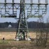 Polizisten ermitteln an dem beschädigten Strommast auf einem Feld in Spreenhagen.