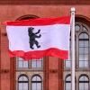 Die rot-weisse Fahne des Landes Berlin mit dem Berliner Bär weht vor dem Roten Rathaus.