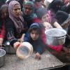 Palästinenser stehen während der israelischen Luft- und Bodenoffensive für die kostenlose Verteilung von Lebensmitteln an.
