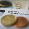 Münzen und Geldscheine liegen neben einem Schreiben mit der Aufschrift «Deutsche Rentenversicherung».