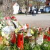 Menschen haben Blumen und Kerzen in Gedenken an den Toten auf dem Parkplatz niedergelegt.