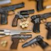 Pistolen und Revolver und Munition liegen auf einem Tisch in einer gesicherten Asservatenkammer.