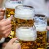 Besucher stoßen auf dem Münchner Oktoberfest mit Bier an. (