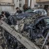 Palästinenser inspizieren zerstörte Fahrzeuge nach einem israelischen Luftangriff.