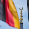 Die deutsche Fahne weht in Garmisch-Partenkirchen (Bayern) neben dem Minarett-Turm der Türkisch-Islamischen Gemeinde Garmisch-Partenkirchen.