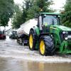 Feuerwehrleute und Helfer pumpen das Wasser von den Straßen in Tankwagen in Dasing in Aichach-Friedberg.