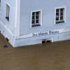 Ein Haus mit dem Schriftzug "Zur blauen Donau" steht im Hochwasser der Donau.