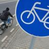 Ein Mann fährt mit seinem Fahrrad auf einem mit einem Verkehrsschild gekennzeichneten Radweg.