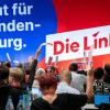 Delegierte halten Stimmkarten bei einer Abstimmung auf dem Landesparteitag von Die Linke Brandenburg in die Höhe.