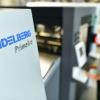 Ein Mitarbeiter steht im Werk der Heidelberger Druckmaschinen AG an einer Digitaldruckmaschine vom Typ «Primefire 106» hinter einem Unternehmenslogo.