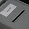 Eine Wahlurne steht in einem Briefwahlbüro.