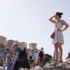 Touristen auf dem Aeropagous-Hügel vor der antiken Akropolis im Zentrum Athens.