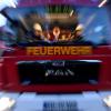 Einsatzkräfte der Feuerwehr sitzen in ihrem Fahrzeug.