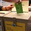 In einem Wahllokal steckt eine Wählerin ihren Stimmzettel für die Kommunalwahl in eine Wahlurne.