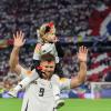 Deutschlands Spieler Niclas Füllkrug trägt nach dem Sieg seine Tochter Emilia durch das Stadion.