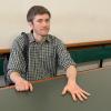 Klimaaktivist Henning Jeschke sitzt festgeklebt an einem Tisch in einem Raum des Amtsgericht Tiergarten.
