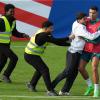 Ein Fan sprintet in Gütersloh auf den Trainingsplatz und umarmt Portugals Superstar Cristiano Ronaldo.