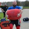 Volle Konzentration: Christian Wohlfarth trägt einen 120 Kilogramm schweren Sandsack. Foto: Wohlfarth