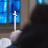 Ein christliches Kreuz wird während einer Solidaritätsaktion vom hereinfallenden Tageslicht angeleuchtet.