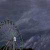 Dunkle Regenwolken ziehen über ein Riesenrad auf dem Gelände des Hurricane-Festivals in Scheeßel hinweg.