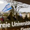 Eine Israel-Flagge spiegelt sich in einer Scheibe der Freien Universität Berlin.