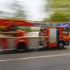 Ein Feuerwehrfahrzeug mit Drehleiter fährt zu einem Einsatz.