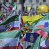 Teilnehmer der Kundgebung schwenken iranische Flaggen.