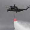 Ein Transporthubschrauber CH-53 entleert das Löschwasser aus dem Wasserbehälter Smokey zur Waldbrandbekämpfung.