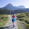 Eine Bergtour mit Schulkind sollte nicht länger als fünf Stunden dauern. Dabei sollten Eltern häufig Pausen einlegen.