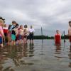 Freiwillige Mitarbeiter der Wasserwacht bringen Kindern am Karlsfelder See das Schwimmen bei.