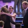 Prinz Harry und Meghan Markle begrüßen andere Anwesende im Publikum der Preis-Gala des US-Sportsenders ESPN.