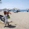 Eine Frau bedeckt ihren Kopf mit einem Schal, als sie einen Strand im Vorort Glyfada, südlich von Athen, verlässt. Die griechischen Behörden haben vor einer drohenden einwöchigen Hitzewelle während der Sommerreisezeit gewarnt, bei der ein hohes Risiko für gefährliche Flächenbrände besteht.