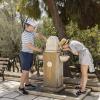 Touristen erfrischen sich während ihres Besuchs der Akropolis an einem öffentlichen Trinkbrunnen. Auch durch den Tourismus ist der Wasserverbrauch zuletzt deutlich gestiegen.