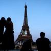 Paris-Touristen vor dem mit den olympischen Ringen geschmückten Eiffelturm.