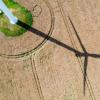 Schattenspiel: der Schatten einer Windkraftanlage fällt auf ein Getreidefeld.