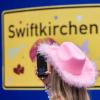 Ein Fan fotografiert vor dem Konzert der Sängerin Taylor Swift in Gelsenkirchen ein «Swiftkirchen»-Schild. Während des Konzerts am Abend zog der Datenverbrauch in den Handynetzen in der Veltins Arena kräftig an.