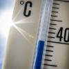 Ein Außenthermometer zeigt vor dem blauen Himmel und der Sonne eine Temperatur von nahezu 40 Grad Celsius an.