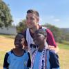 Die Spieler des FC Augsburg sind in Südafrika beliebte Fotomotive. Keven Schlotterbeck nach dem Training mit zwei Jugendlichen, die selbst Fußball spielen.